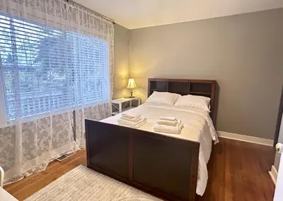 a bedroom with a bed and a large window at Airport-YVR GuestHouse in Richmond