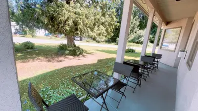a porch with chairs and tables and a tree at Cornerstone Bed and Breakfast in Revelstoke