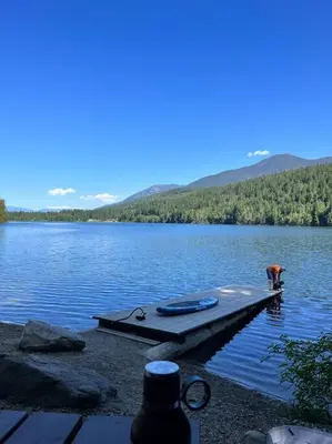 a person standing on a dock in a lake at Michaud's Basement unit in Nakusp