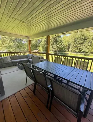 a wooden deck with a table and chairs on a porch at Caribou Lodge in Terrace
