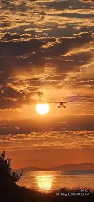 an airplane flying over the ocean at sunset at Terra Nova - Private property in Richmond