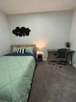 a bedroom with a bed and a desk and a desk at Comfortable and centrally located guest suite in Calgary