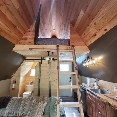 a loft bed in a tiny house at Mushroom theme cabin on 33 Acre Farm in Brew Bay