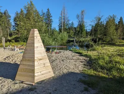 a wooden boardwalk in the sand in a field at Mushroom theme cabin on 33 Acre Farm in Brew Bay