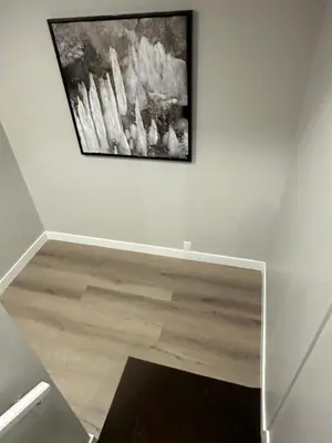 a painting hanging on a white wall in a room at A Luxurious Cozy Place in Calgary