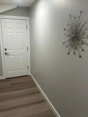 a white room with a white door and a chandelier at A Luxurious Cozy Place in Calgary