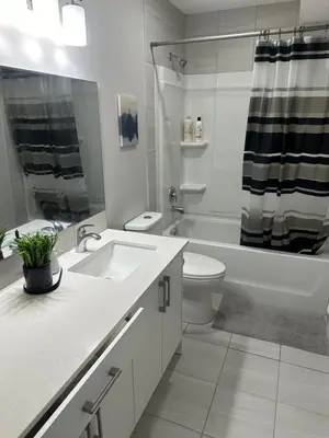 a bathroom with a sink and a toilet and a tub at A Luxurious Cozy Place in Calgary