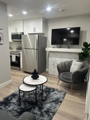 a kitchen with a refrigerator and a chair and a table at A Luxurious Cozy Place in Calgary