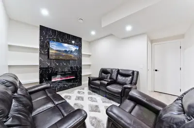 a living room with leather furniture and a fireplace at Executive Bliss Suites in Calgary