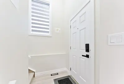 a hallway with a white door and a window at Executive Bliss Suites in Calgary