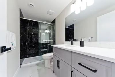 a white bathroom with a toilet and a shower at Executive Bliss Suites in Calgary