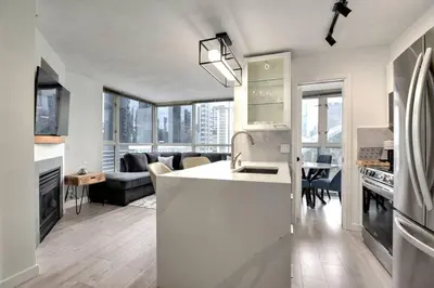 a kitchen and living room with a white counter top at Luxury Condo in Downtown Vancouver with city view in Vancouver