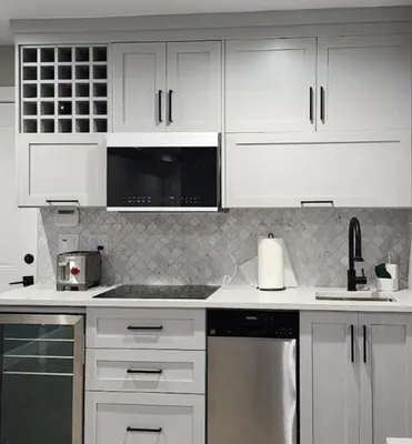 a kitchen with white cabinets and a stove top oven at Modern West Coast Contemporary Suite in Vancouver