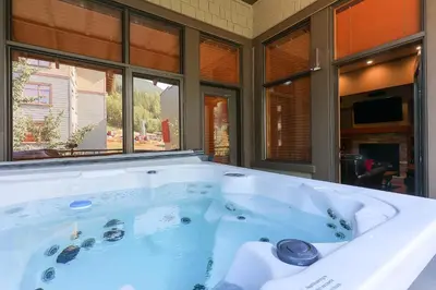 a large bath tub in a room with windows at Slalom Creek 3 Bedrooms in Rossland