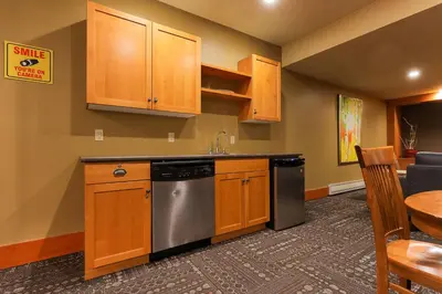 a kitchen with wooden cabinets and a stainless steel dishwasher at Slalom Creek 2 Bedrooms in Rossland
