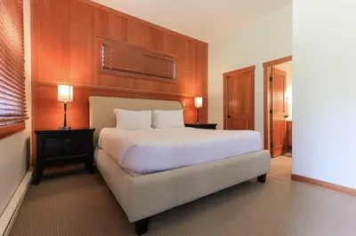 a bedroom with a large white bed and a window at Slalom Creek 3 Bedroom in Rossland