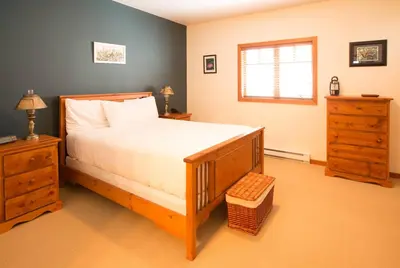 a bedroom with a bed and a dresser and a window at Silver Tip 2 Bedroom Condo in Rossland