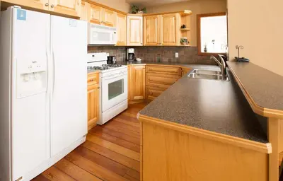 a kitchen with white appliances and wooden cabinets at White Wolf in Rossland