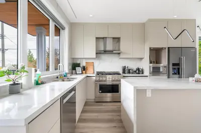 a kitchen with white cabinets and white counter tops at Charming and Modern Retreat in Vancouver Trendy 42nd Avenue Neighbourhood in Vancouver