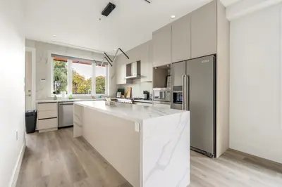 a kitchen with white cabinets and a large kitchen island at Charming and Modern Retreat in Vancouver Trendy 42nd Avenue Neighbourhood in Vancouver