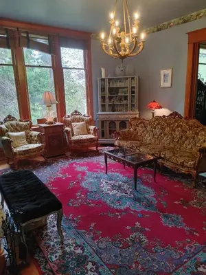 a living room with a couch and a red rug at Hummingbird Gardens B&B in Ladysmith