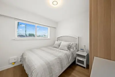 a white bedroom with a bed and a window at Cozy 3BR Holiday Retreat 2 Free Parking AC King BD in Vancouver