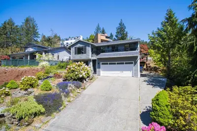 a house with a driveway and a garage at Trader Vics Tiki Bar n Grill in Nanaimo