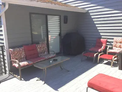 a porch with two couches and a table and chairs at Trader Vics Tiki Bar n Grill in Nanaimo