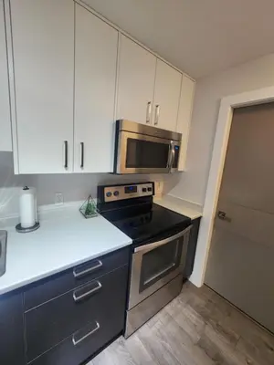 a kitchen with a stove and a microwave at Cozy Royal Bay Suite in Victoria