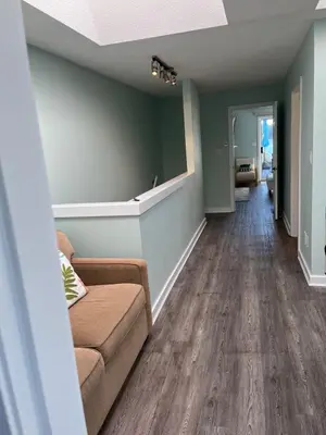a living room with a couch and wood floors at Aloha Cottage, Nanoose Bay - 2 Bdrm Oceanfront Unit with Private Deck in Nanoose Bay