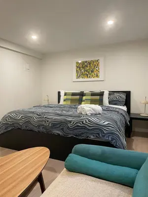 a bedroom with a large bed and a table at Almost Home in West Vancouver