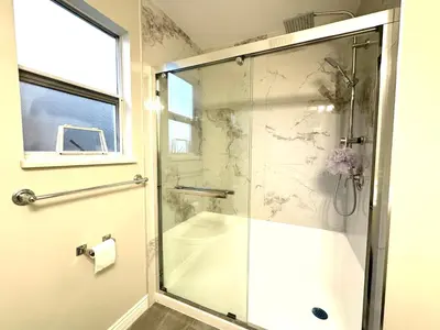a shower with a glass door in a bathroom at Newly renovated 2 bed 1 bath in Ladner BC in Delta