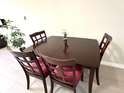 a dining room table with chairs and a vase with flowers at Newly renovated 2 bed 1 bath in Ladner BC in Delta
