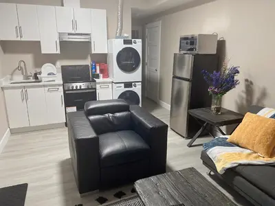 a kitchen with a couch and a chair in a living room at Home away from home in Prince George
