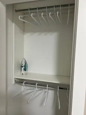 a closet with white hangers and a mirror at Home away from home in Prince George