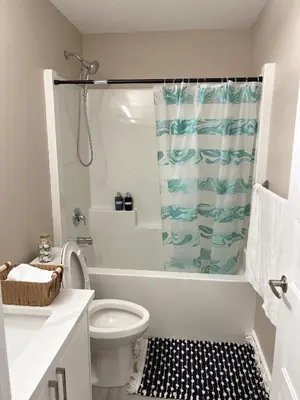 a bathroom with a toilet and a shower curtain at Home away from home in Prince George
