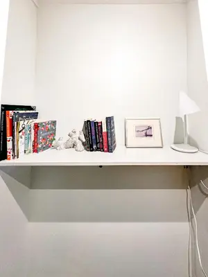 a white shelf with books and a lamp on it at Swallow's Perch Guest Suite in Vesuvius
