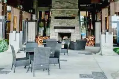 a patio with chairs and a table and a fireplace at ENTIRE Sunrise Resort Townhome in Parksville in Parksville