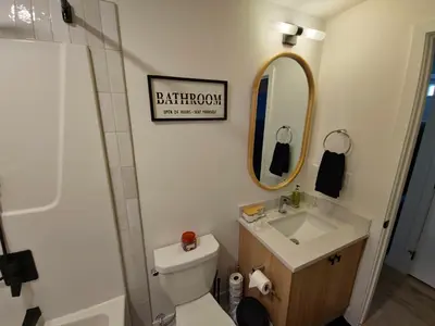 a bathroom with a toilet and a sink and a mirror at A stylish 2 BDR with a blend of cozy and peace! in Calgary