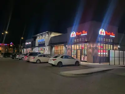 a row of cars parked in a parking lot at night at A stylish 2 BDR with a blend of cozy and peace! in Calgary