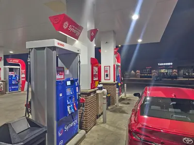 a red car is parked next to a gas pump at A stylish 2 BDR with a blend of cozy and peace! in Calgary