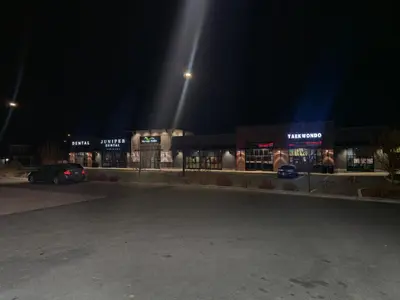 a parking lot in front of a store at night at A stylish 2 BDR with a blend of cozy and peace! in Calgary
