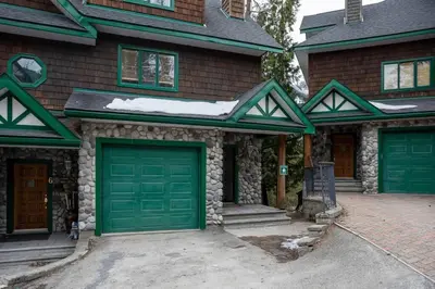 a house with two green garage doors on it at Cedar Ridge Estates by StayIn in Fernie