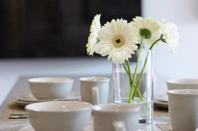 a vase of flowers sitting on a table with cups at Executive Condo In Old Town Victoria in Victoria