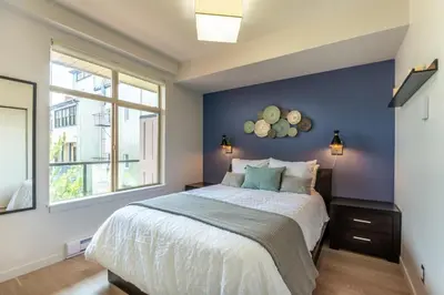 a bedroom with a large bed with a blue wall at Executive Condo In Old Town Victoria in Victoria