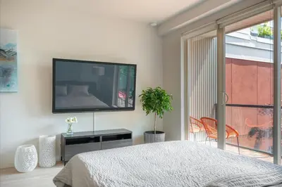 a bedroom with a flat screen tv on the wall at Executive Condo In Old Town Victoria in Victoria