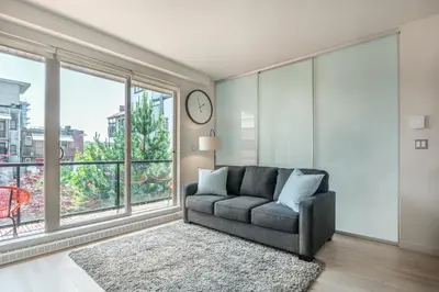 a living room with a couch and a large window at Executive Condo In Old Town Victoria in Victoria