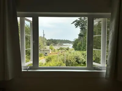 a window in a room with a view of a field at Silva Bay View BnB in Gabriola