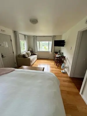 a bedroom with a bed and a living room at Silva Bay View BnB in Gabriola