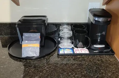 a tray with a coffee maker and other items on a counter at The Kanata Bonnyville in Bonnyville